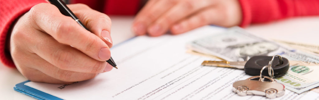 Hand holding a pen signing a contract